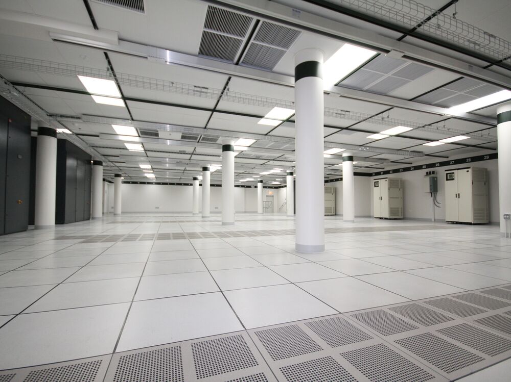 Raised-floor data hall with white columns and cabinet rows